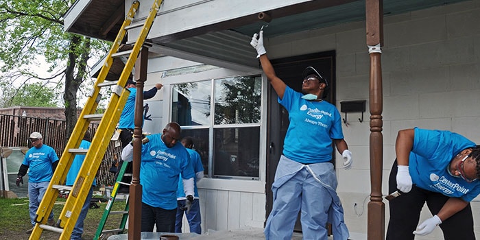 several Centerpoint employees volunteering by painting a home