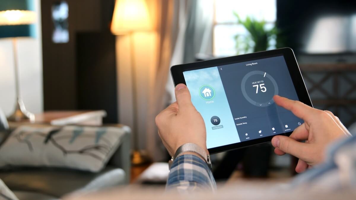 Man adjusting home temperature with a tablet