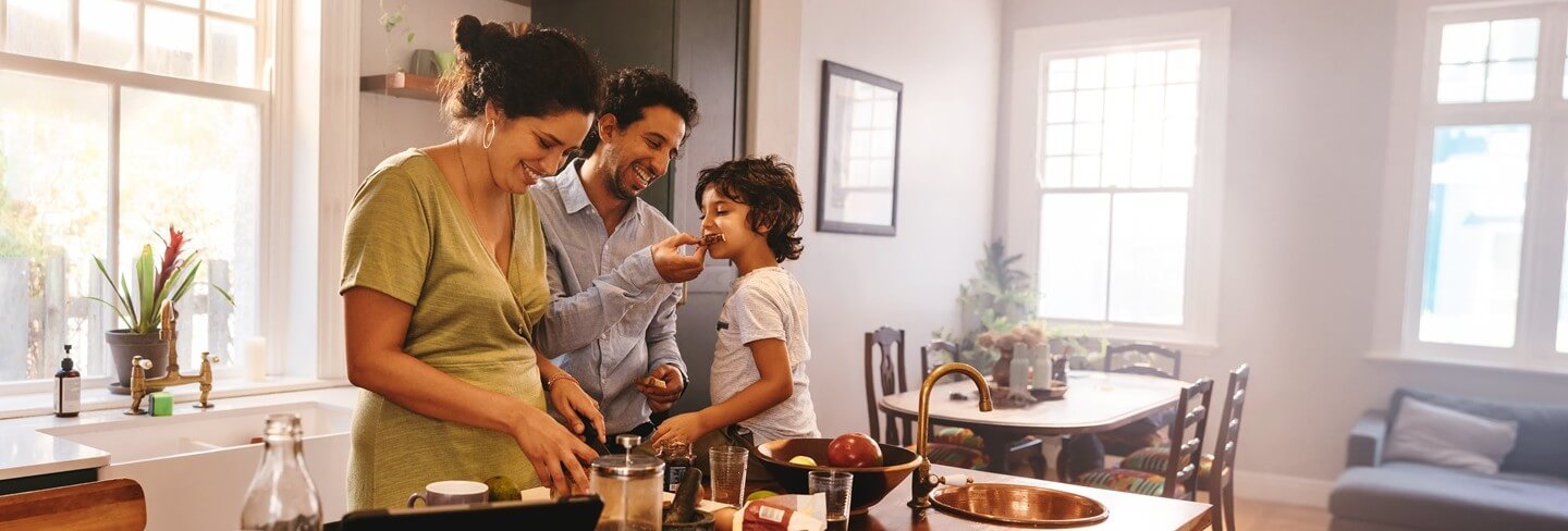 Father feeding son during family meal prep