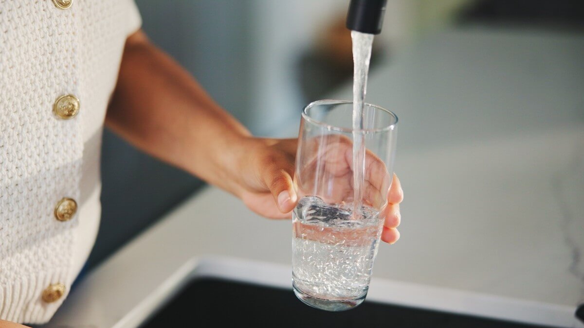 Pouring a glass of water from a faucet
